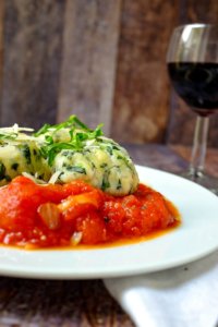 Holt euch ein Stück Italien nach Hause: Spinat-Ricotta-Klöße in einer Tomaten-Sugo.
