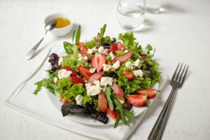 Ein wunderbar fruchtiger Frühlingssalat zum Genießen: Salat mit karamellisiertem Rhabarber, Erdbeeren und Hirtenkäse.