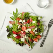Ein wunderbar fruchtiger Frühlingssalat zum Genießen: Salat mit karamellisiertem Rhabarber, Erdbeeren und Hirtenkäse.