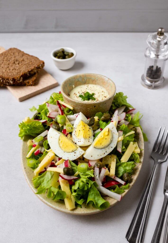 Dieser herzhafte Käse-Ei-Salat schmeckt köstlich. Die Kombination aus sauren Gurken, salzigen Kapern, milden Käse und leicht scharfen Radieschen macht dem Gaumen Spaß. Egal ob aus Partysalat oder leckerem Snack. 