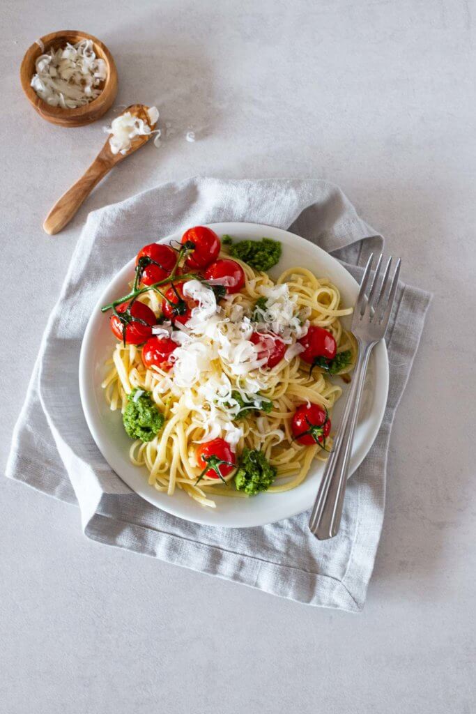 Diese Pasta mit selbstgemachtem Rucola-Pesto und warmen Zwiebel-Tomaten ist eine wahre Geschmackssensation. Abgerundet mit frisch geriebenen Parmesan wirklich köstlich.