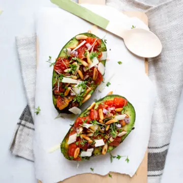Gefüllte Avocados mit Tomaten, Parmesan, gerösteten Pinienkernen und frischer Kresse