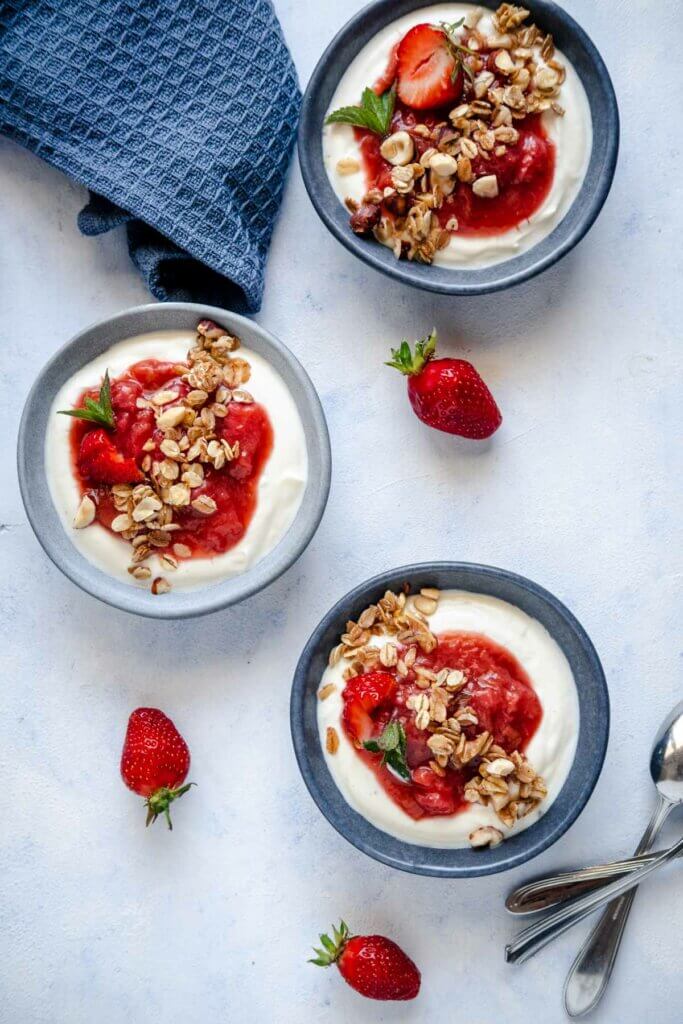 Rhabarber-Erdbeer-Kompott mit Joghurtcreme und Knuspermüsli mit Erdbeeren als Deko.