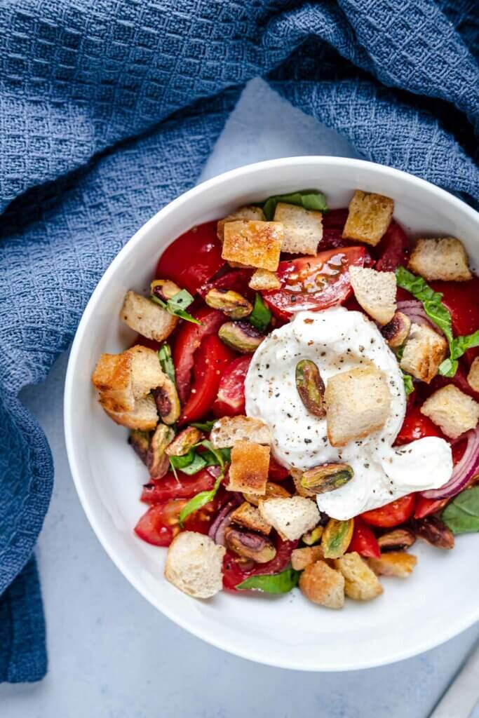 Tomaten-Burrata-Salat mit Pistazien-Croutons in Nahaufnahme