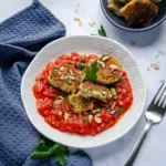 Diese Zucchini-Frischkäse-Taler in Tomatensauce schmecken köstlich.
