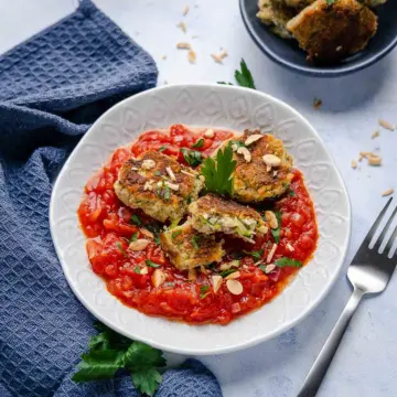 Diese Zucchini-Frischkäse-Taler in Tomatensauce schmecken köstlich.