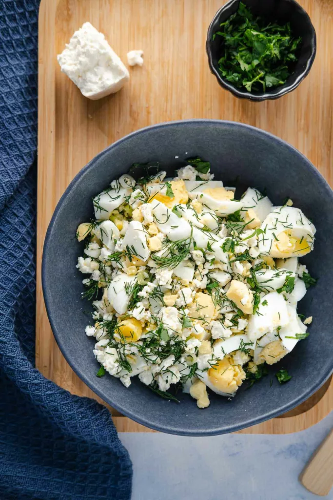 Mediterraner Eiersalat (ohne Mayonnaise) in einer blauen Schüssel